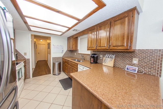 kitchen featuring backsplash, white appliances, sink, and light tile patterned floors