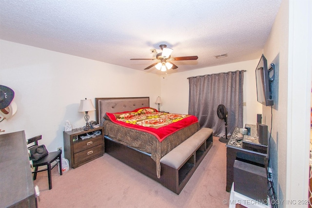 carpeted bedroom with ceiling fan and a textured ceiling