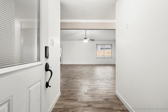 corridor with hardwood / wood-style flooring, vaulted ceiling, and a textured ceiling