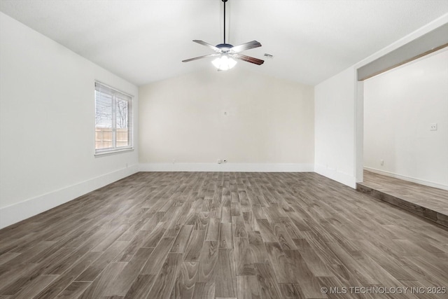 spare room with vaulted ceiling, dark hardwood / wood-style floors, and ceiling fan