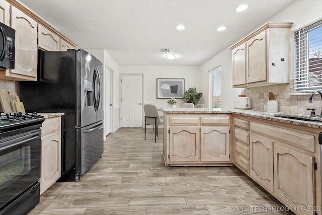 kitchen with backsplash, sink, light brown cabinets, and black appliances