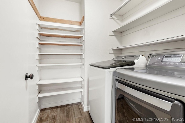 laundry room with hardwood / wood-style floors and washing machine and clothes dryer