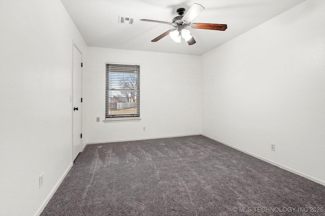 empty room with ceiling fan and dark colored carpet