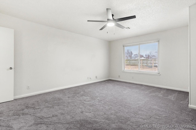 empty room featuring ceiling fan, a textured ceiling, and dark carpet