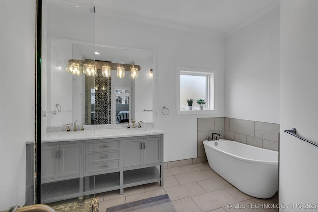 bathroom featuring vanity, crown molding, tile patterned floors, and a tub