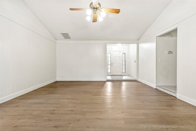 unfurnished room with ceiling fan, vaulted ceiling, and wood-type flooring