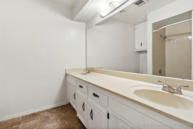 bathroom with vanity and tiled shower