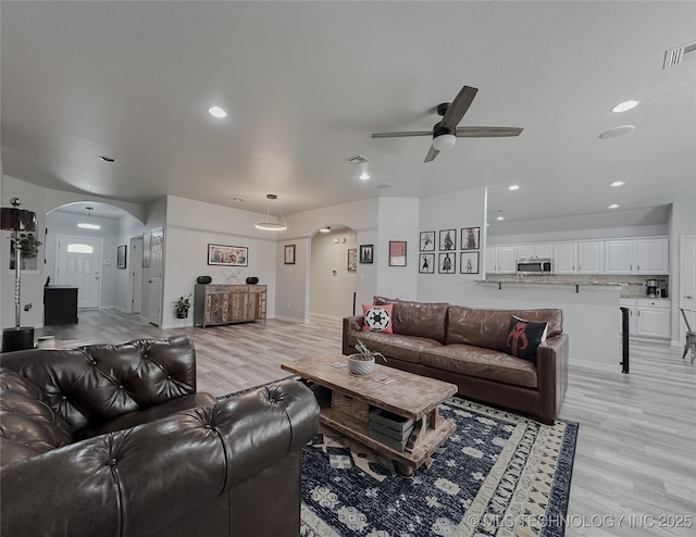 living room featuring light hardwood / wood-style flooring and ceiling fan