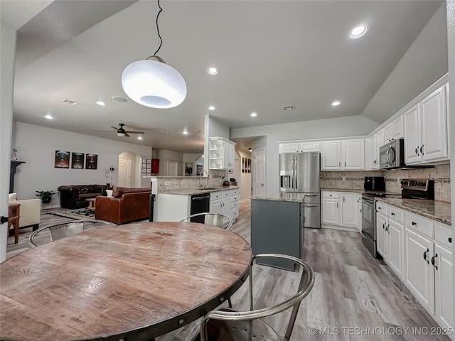 dining room featuring lofted ceiling, sink, ceiling fan, and light hardwood / wood-style flooring