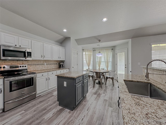 kitchen featuring a kitchen island, white cabinetry, appliances with stainless steel finishes, and sink