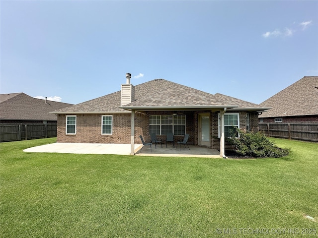 back of property with a yard and a patio area