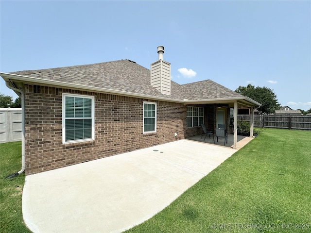 back of property featuring a patio and a yard