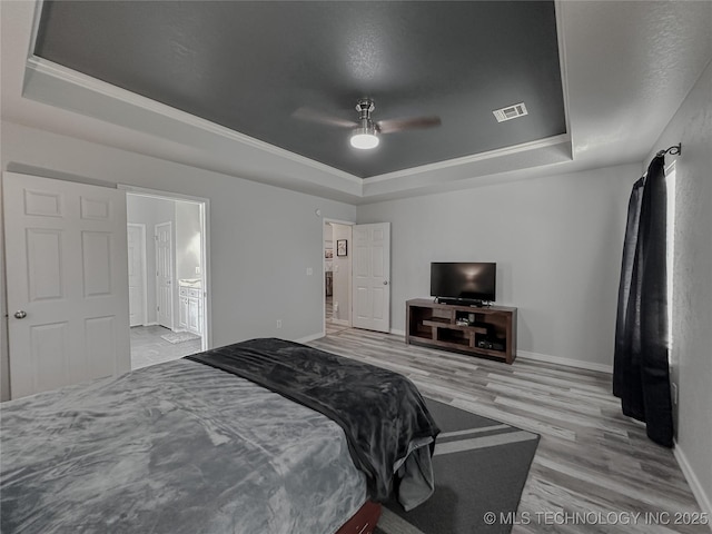 bedroom featuring hardwood / wood-style floors, ceiling fan, and a tray ceiling