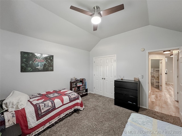 bedroom featuring vaulted ceiling, a closet, ceiling fan, and dark colored carpet