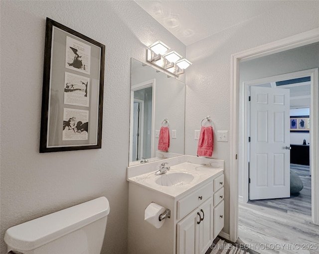 bathroom featuring vanity, toilet, and hardwood / wood-style floors