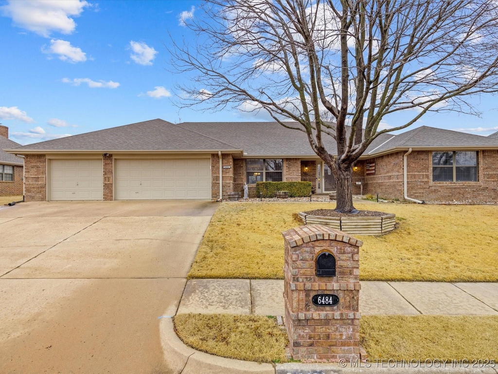 single story home featuring a garage and a front lawn