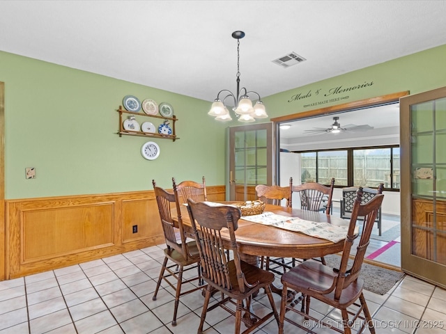 tiled dining room featuring a chandelier