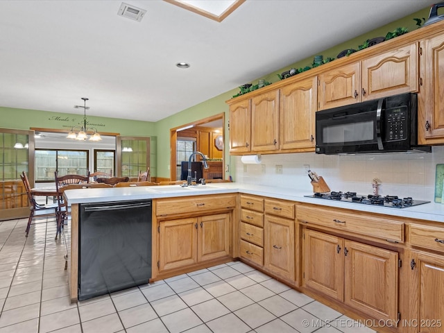 kitchen with hanging light fixtures, plenty of natural light, kitchen peninsula, and black appliances