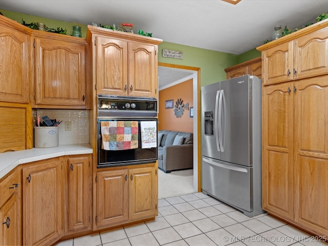 kitchen with tasteful backsplash, stainless steel fridge, oven, and light tile patterned flooring