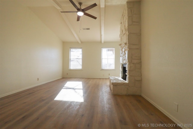 unfurnished living room with lofted ceiling with beams, a stone fireplace, dark wood-type flooring, and ceiling fan