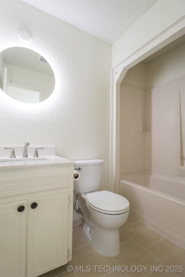 full bathroom with washtub / shower combination, tile patterned floors, toilet, a textured ceiling, and vanity