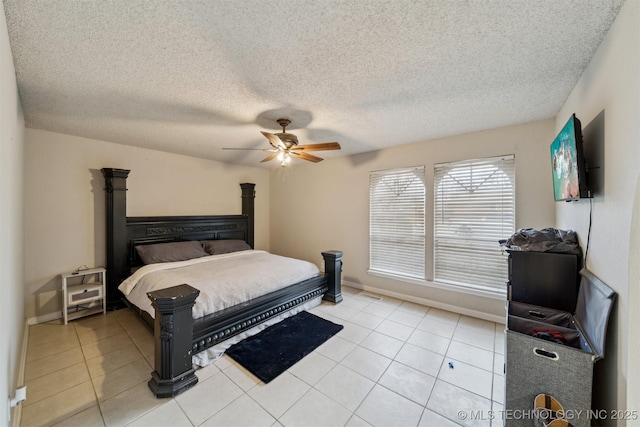 bedroom with a textured ceiling, ceiling fan, and light tile patterned flooring