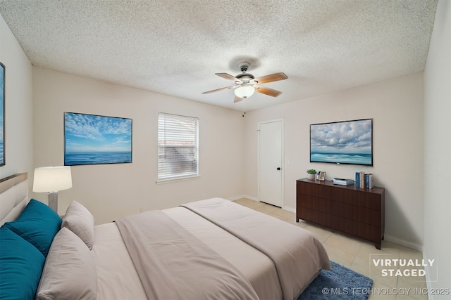 bedroom featuring ceiling fan, light tile patterned floors, and a textured ceiling