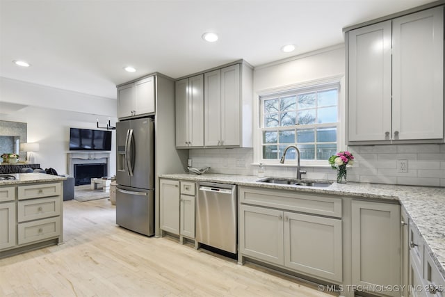 kitchen featuring light stone counters, sink, gray cabinets, and appliances with stainless steel finishes