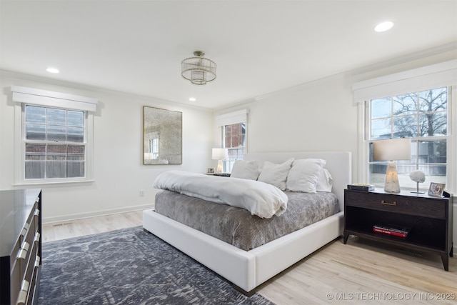 bedroom with crown molding and light hardwood / wood-style flooring