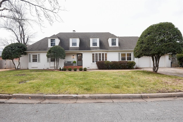 cape cod house featuring a garage and a front lawn