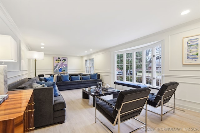 living room with light hardwood / wood-style flooring and ornamental molding