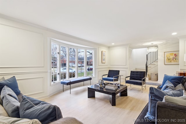 living room with ornamental molding and light wood-type flooring