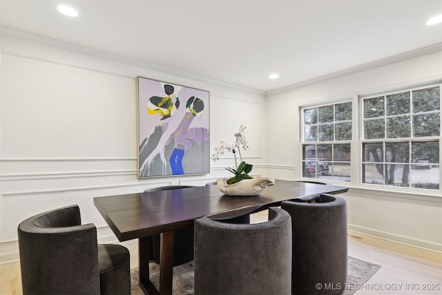 dining area with ornamental molding and light wood-type flooring