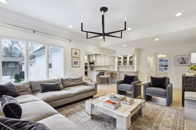 living room with a notable chandelier and light wood-type flooring