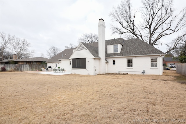 rear view of house featuring a patio and a lawn