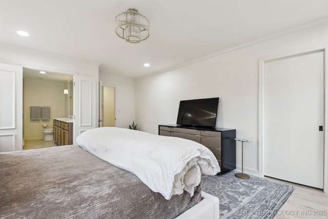 bedroom with crown molding, connected bathroom, and light wood-type flooring