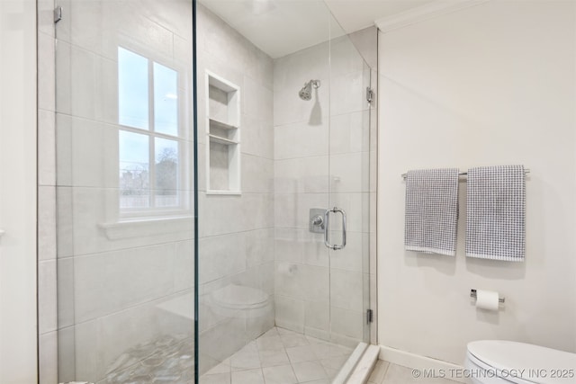 bathroom featuring a shower with shower door and toilet