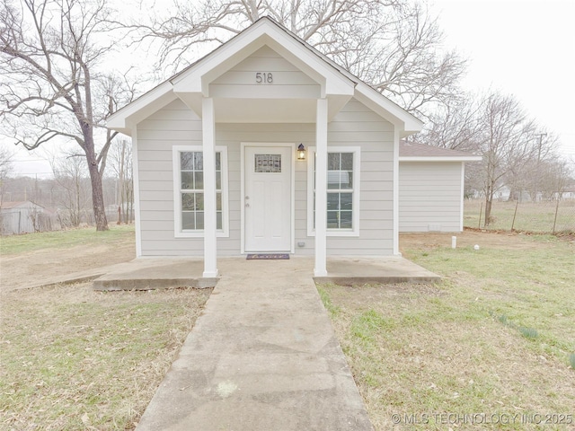 bungalow-style home with a front yard