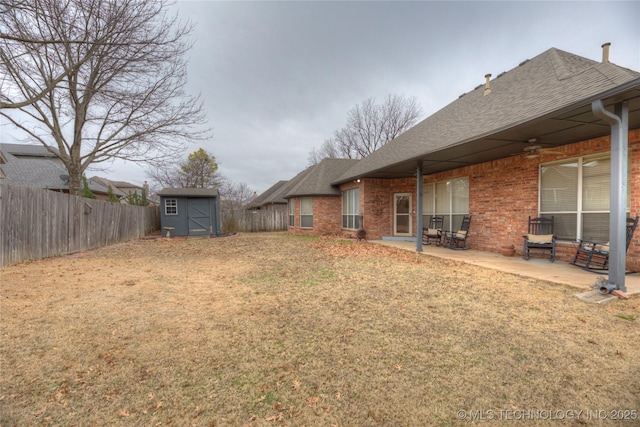 view of yard featuring ceiling fan, a shed, and a patio