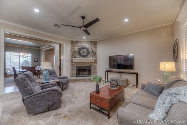 carpeted living room featuring ceiling fan with notable chandelier, a fireplace, and ornamental molding