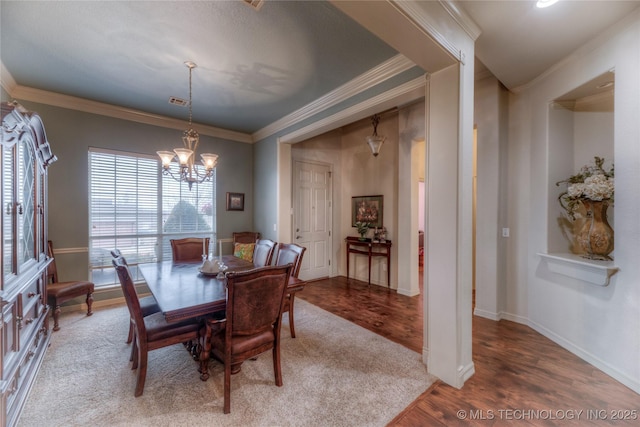 dining room with ornamental molding, a chandelier, and hardwood / wood-style floors