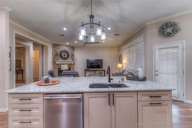 kitchen featuring sink, light stone counters, decorative light fixtures, stainless steel dishwasher, and white cabinets