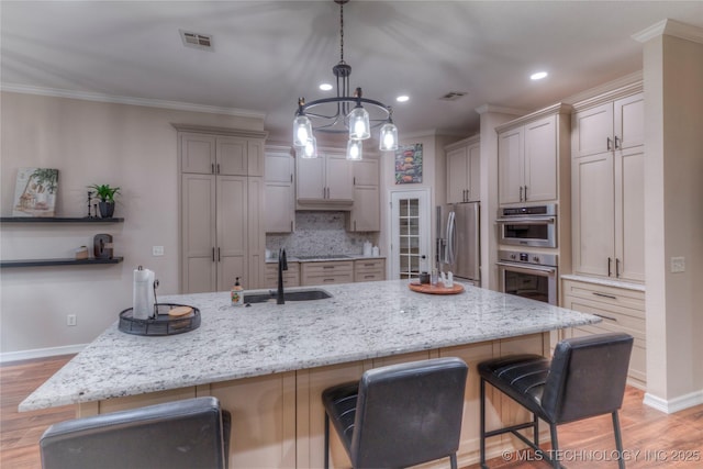 kitchen featuring sink, a breakfast bar area, stainless steel appliances, and hanging light fixtures