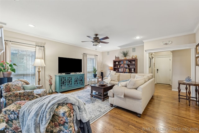 living room featuring hardwood / wood-style floors, crown molding, a wealth of natural light, and ceiling fan