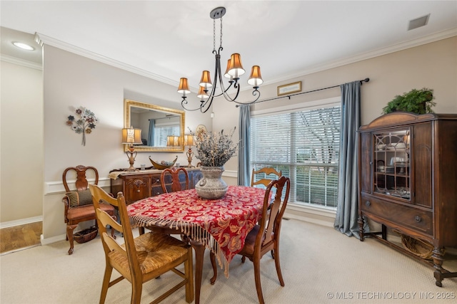 carpeted dining area featuring crown molding and a chandelier