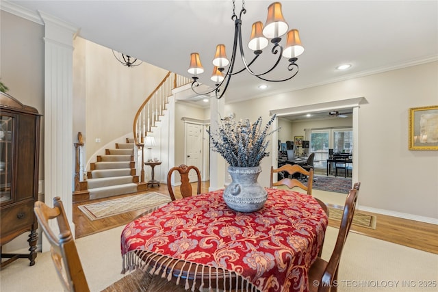 dining room with ornamental molding, wood-type flooring, a chandelier, and ornate columns