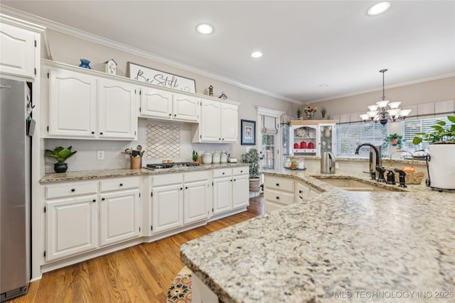 kitchen with white cabinetry, appliances with stainless steel finishes, sink, and pendant lighting