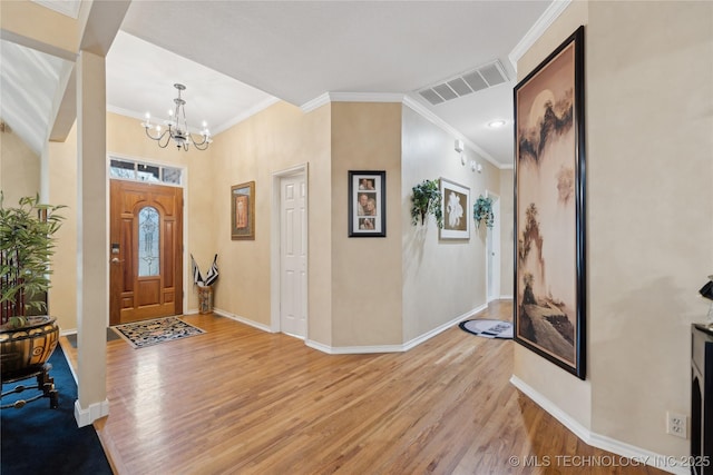 entrance foyer featuring crown molding, a notable chandelier, and light hardwood / wood-style flooring