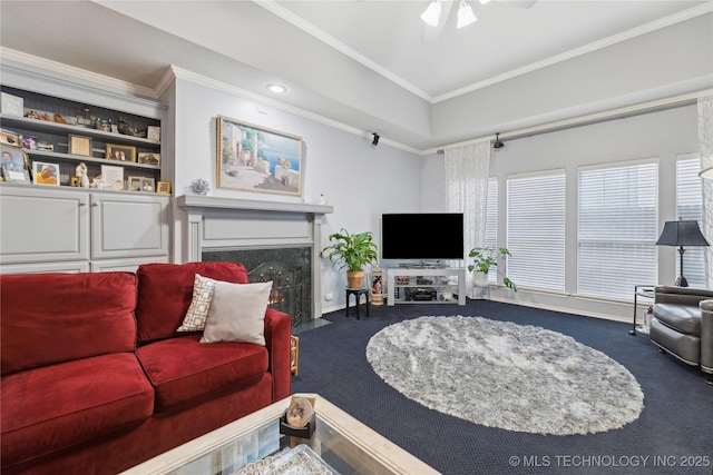 carpeted living room with a premium fireplace, crown molding, and ceiling fan