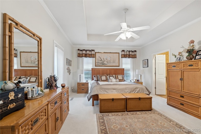 bedroom featuring ornamental molding, light carpet, and a tray ceiling